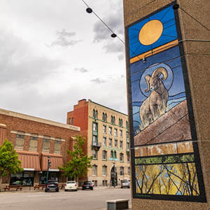 Big Horn Sheep and golden sun mural on building